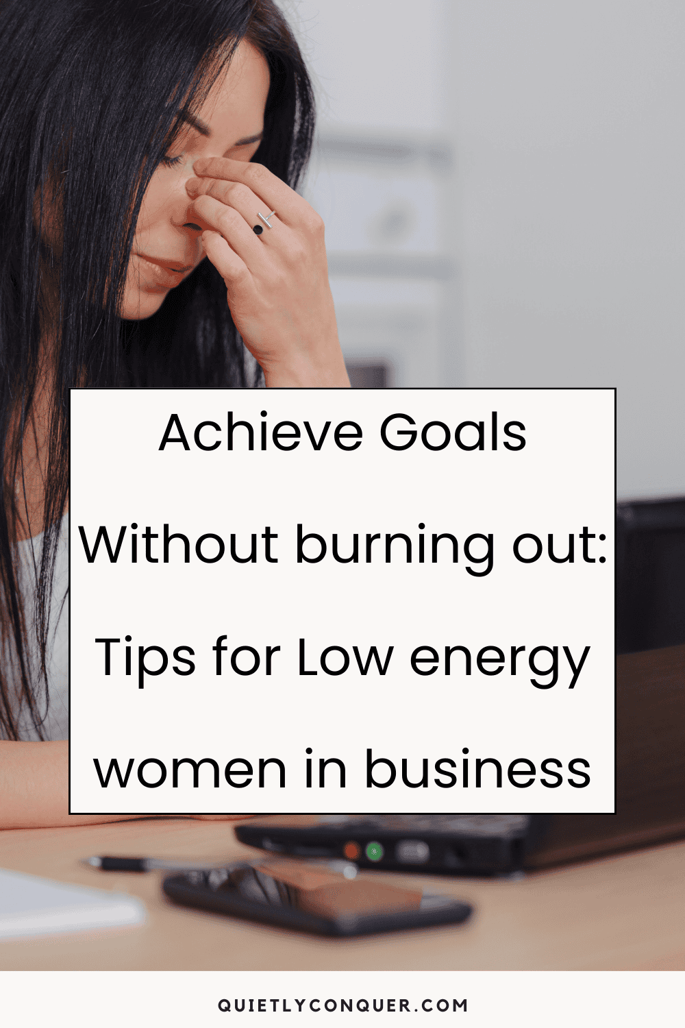 A woman sat at desk looking tired with her fingers each side of her nose, eyes closed. The text "Achieve Goals Without Burning Out: Tips for Low Energy Women in Business" in front of the image